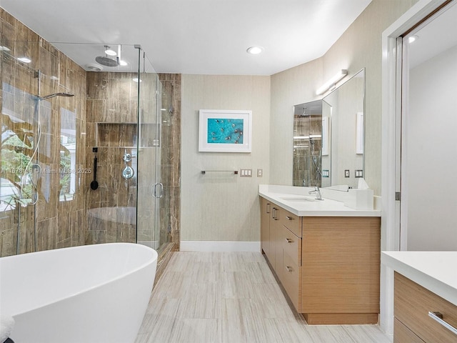 full bath with a freestanding tub, baseboards, a stall shower, and vanity