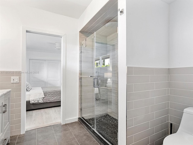 full bathroom with toilet, tile walls, a stall shower, and tile patterned flooring