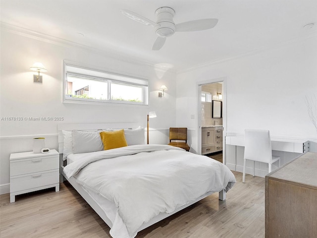 bedroom featuring crown molding, baseboards, ceiling fan, ensuite bathroom, and wood finished floors