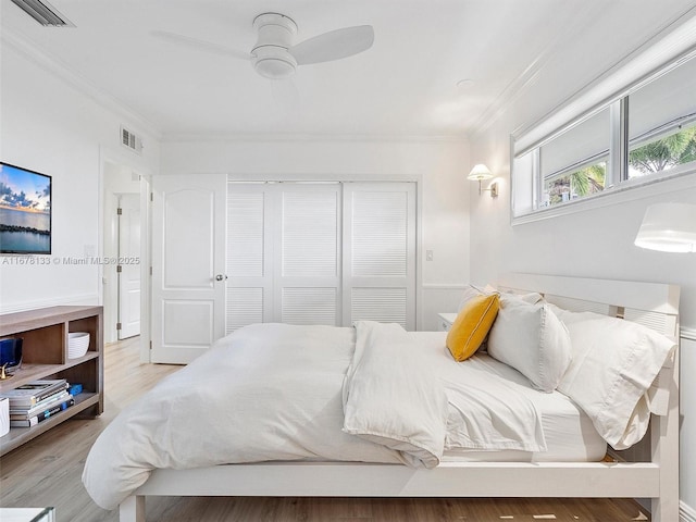 bedroom featuring crown molding, visible vents, and a closet