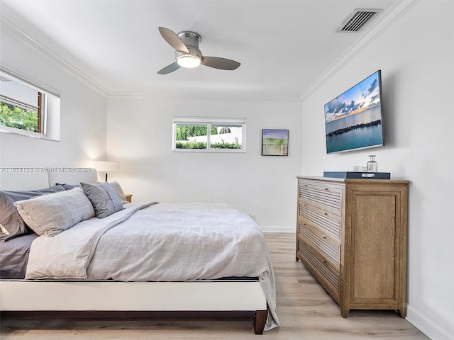 bedroom with crown molding, baseboards, visible vents, and light wood-type flooring