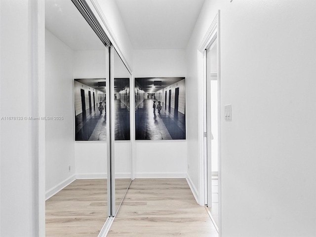 hall featuring baseboards and wood finished floors