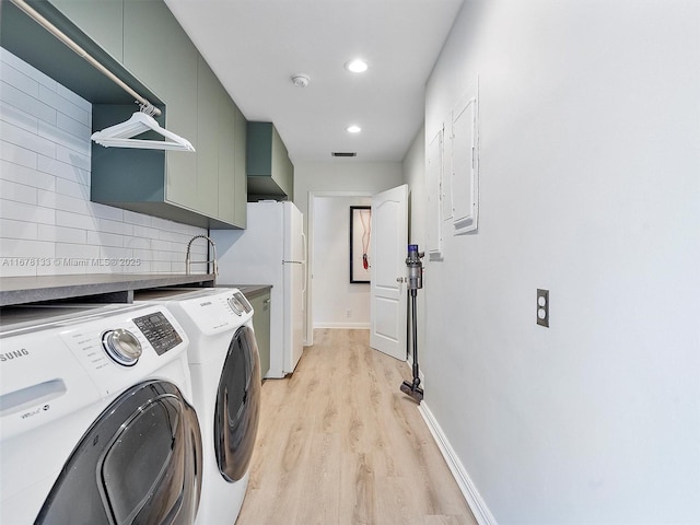 laundry room with visible vents, independent washer and dryer, light wood-style flooring, cabinet space, and baseboards