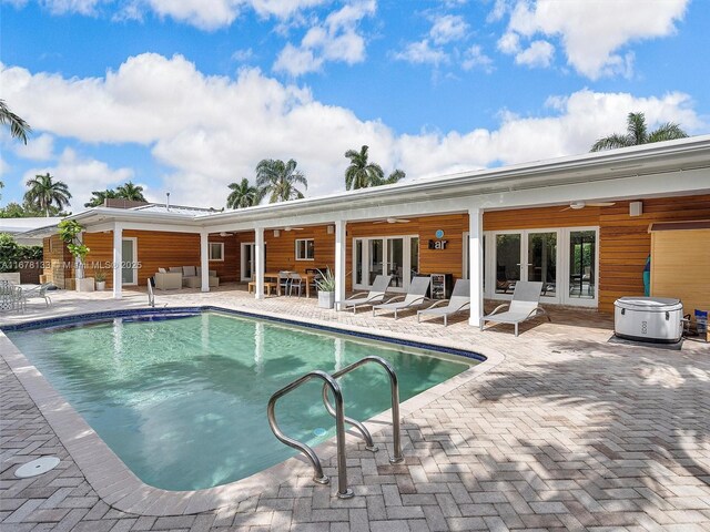 pool at dusk featuring a patio, french doors, and an outdoor hangout area