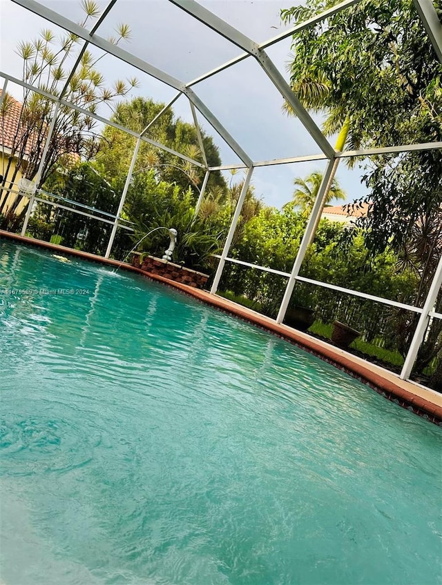 view of pool with pool water feature and a lanai