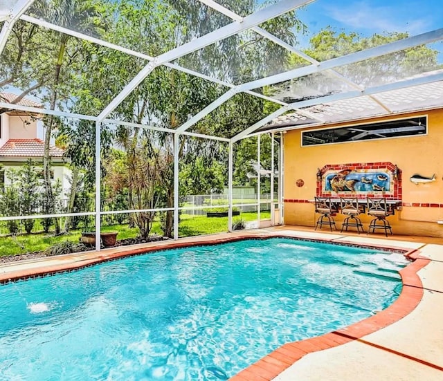 view of pool featuring pool water feature, a patio area, and glass enclosure