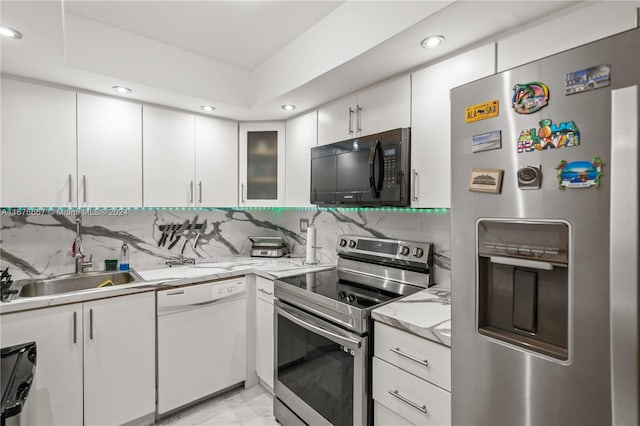 kitchen featuring white cabinetry, backsplash, stainless steel appliances, and sink