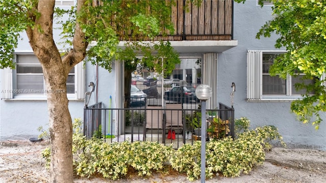 view of exterior entry featuring a balcony