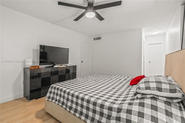 bedroom featuring ceiling fan, a textured ceiling, and light hardwood / wood-style flooring