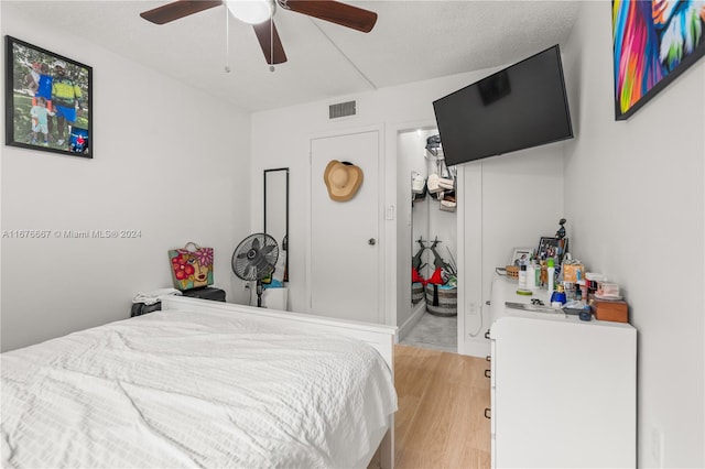 bedroom featuring a textured ceiling, light hardwood / wood-style floors, and ceiling fan