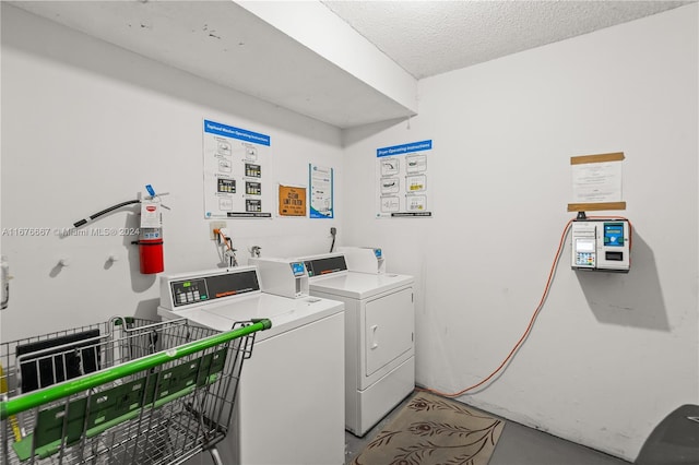 clothes washing area featuring a textured ceiling and washing machine and clothes dryer