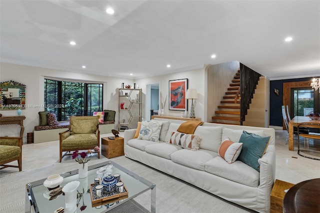 tiled living room featuring ornamental molding, a wealth of natural light, and an inviting chandelier