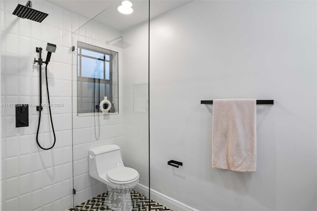 bathroom featuring tile walls, tiled shower, and toilet