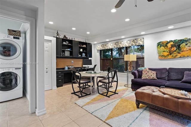 living room with ornamental molding, stacked washer and dryer, light tile patterned floors, and ceiling fan