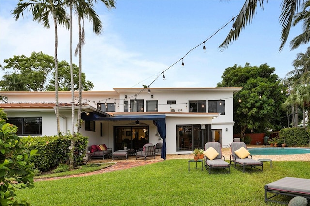 rear view of property with a patio and a lawn