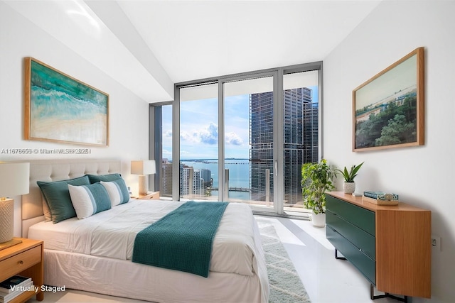 bedroom with a wall of windows, a water view, and access to outside