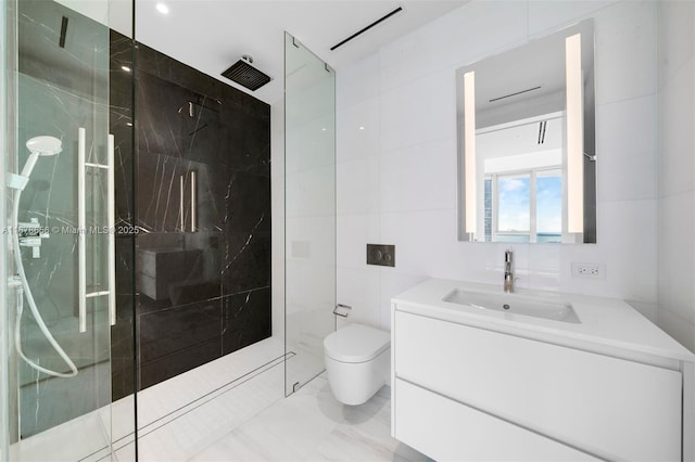 bathroom with tile walls, toilet, vanity, and tiled shower