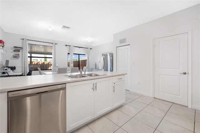 kitchen with light tile patterned flooring, white cabinetry, stainless steel dishwasher, and sink