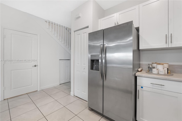 kitchen with white cabinets, light tile patterned floors, and stainless steel fridge with ice dispenser