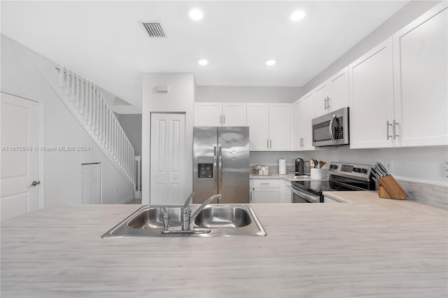 kitchen with sink, appliances with stainless steel finishes, and white cabinets