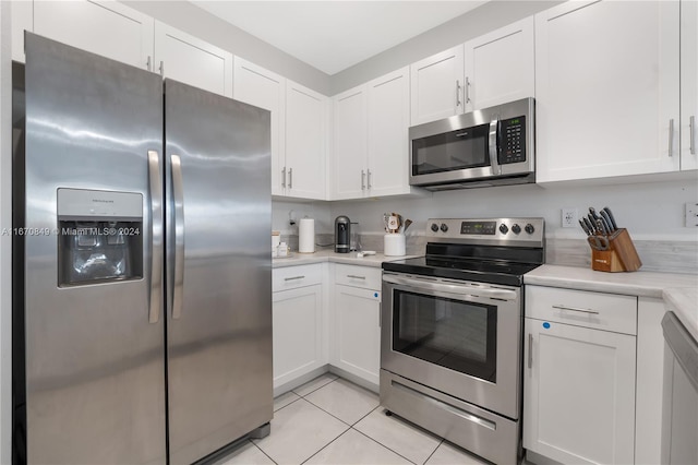 kitchen featuring light tile patterned flooring, white cabinetry, and stainless steel appliances