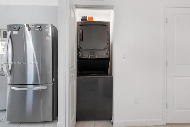 interior space featuring stacked washer and clothes dryer, light tile patterned floors, and stainless steel refrigerator