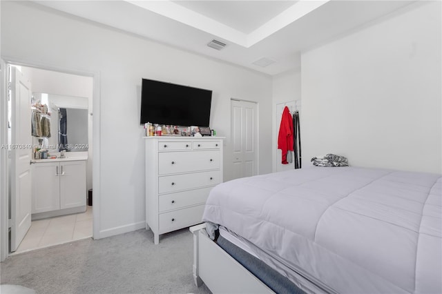 carpeted bedroom with a closet and ensuite bath