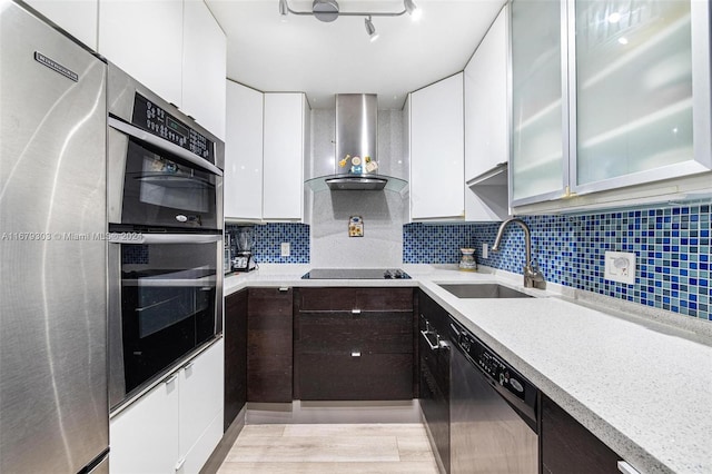 kitchen featuring stainless steel appliances, sink, white cabinets, light hardwood / wood-style floors, and tasteful backsplash