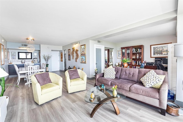 living area with visible vents and wood finished floors