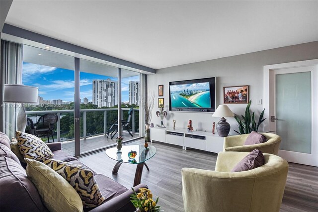 living room featuring a wealth of natural light, hardwood / wood-style floors, and floor to ceiling windows