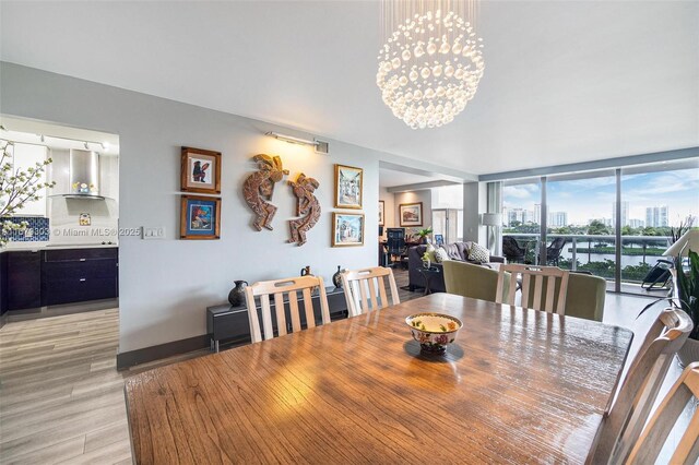 dining room featuring light hardwood / wood-style flooring, an inviting chandelier, and floor to ceiling windows