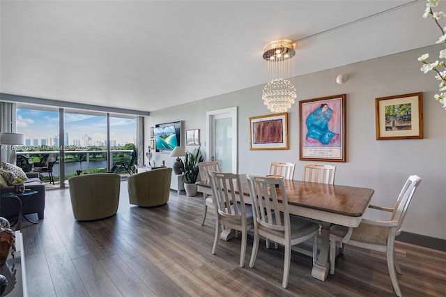 dining room featuring dark wood-style flooring, a water view, an inviting chandelier, a wall of windows, and a city view