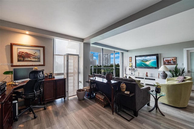 home office featuring floor to ceiling windows and wood finished floors