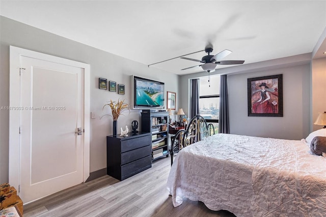 bedroom with a ceiling fan, baseboards, and light wood finished floors