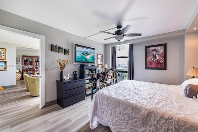 bedroom featuring light wood-style floors, ceiling fan, and baseboards