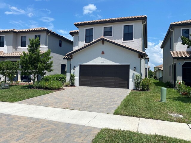 mediterranean / spanish home with central air condition unit, a front yard, and a garage