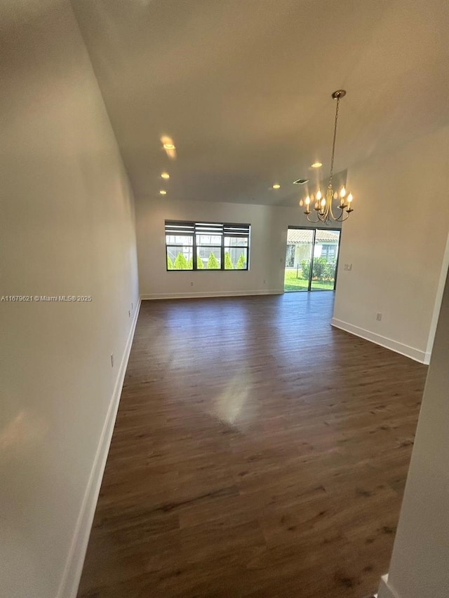 unfurnished room with an inviting chandelier, baseboards, dark wood-style floors, and recessed lighting