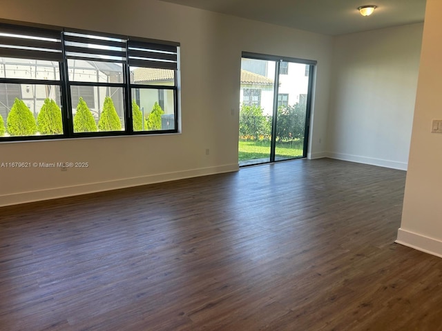 unfurnished room featuring dark wood-type flooring and baseboards