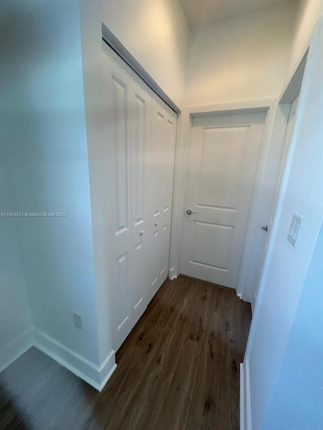 hallway with dark wood-style floors and baseboards