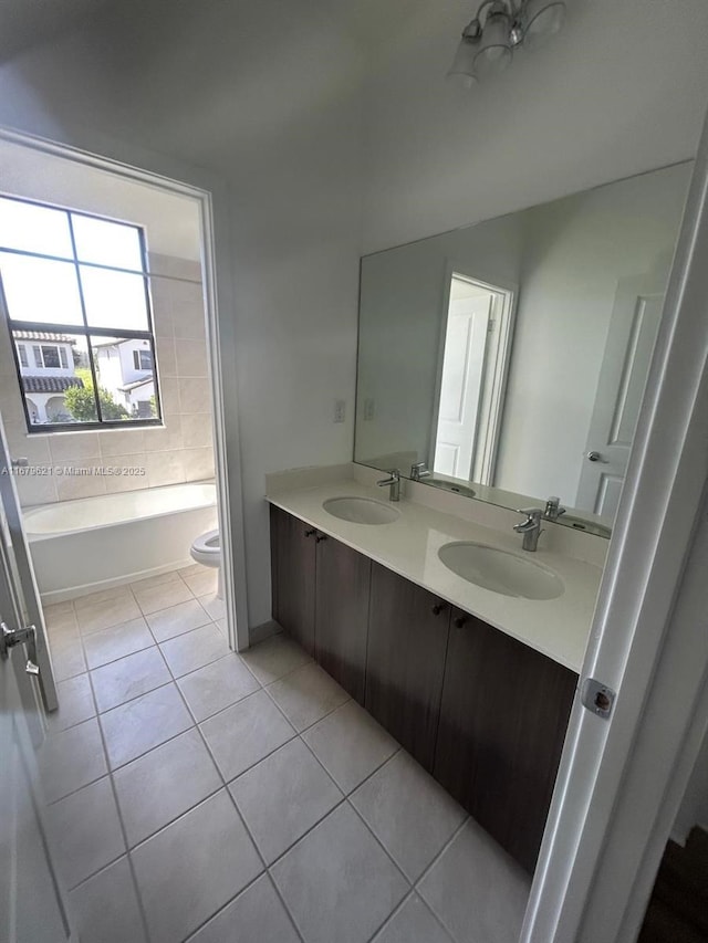 bathroom with a bathtub, tile patterned flooring, a sink, and toilet