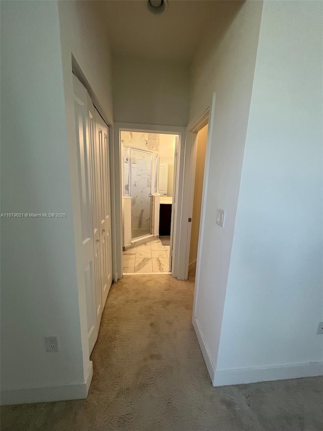 hall featuring light carpet and baseboards