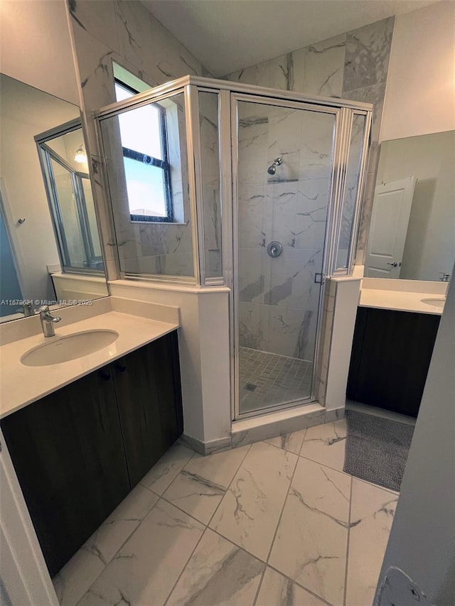 bathroom with marble finish floor, a marble finish shower, two vanities, and a sink