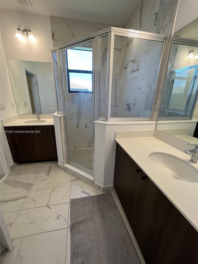 bathroom with marble finish floor, two vanities, a sink, and a marble finish shower