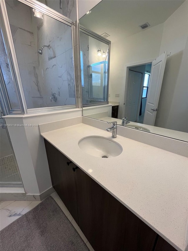 full bathroom featuring marble finish floor, a shower stall, visible vents, and vanity