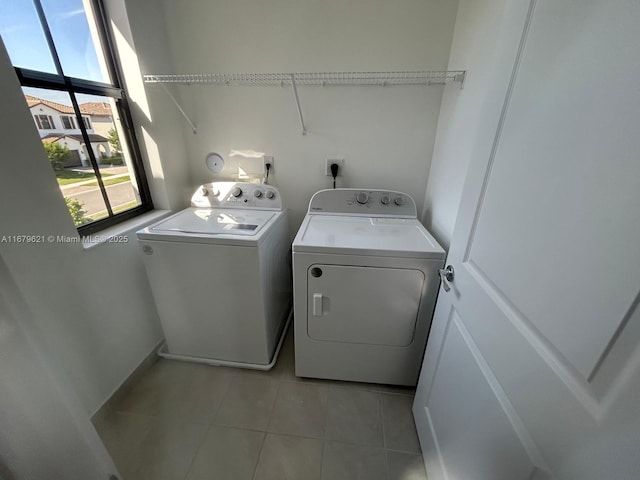 laundry room with light tile patterned floors, laundry area, and separate washer and dryer