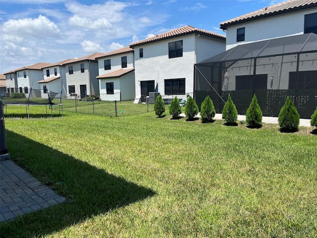 view of yard with a lanai, a residential view, and fence