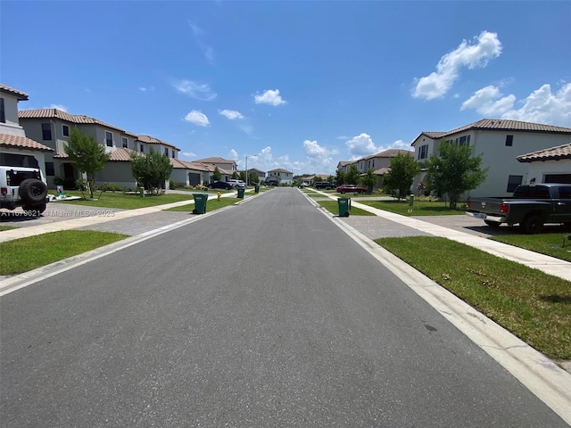 view of road with sidewalks, a residential view, and curbs