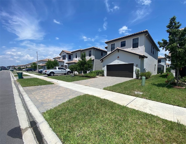 view of front facade with a garage, a residential view, decorative driveway, a front lawn, and stucco siding