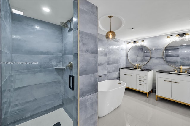 bathroom featuring vanity, tile walls, and independent shower and bath