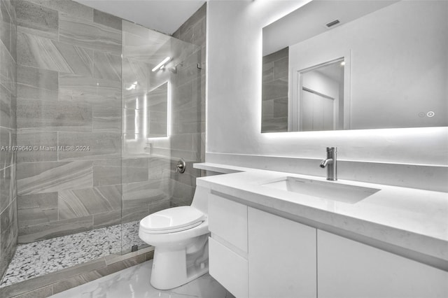 bathroom with vanity, toilet, and tiled shower